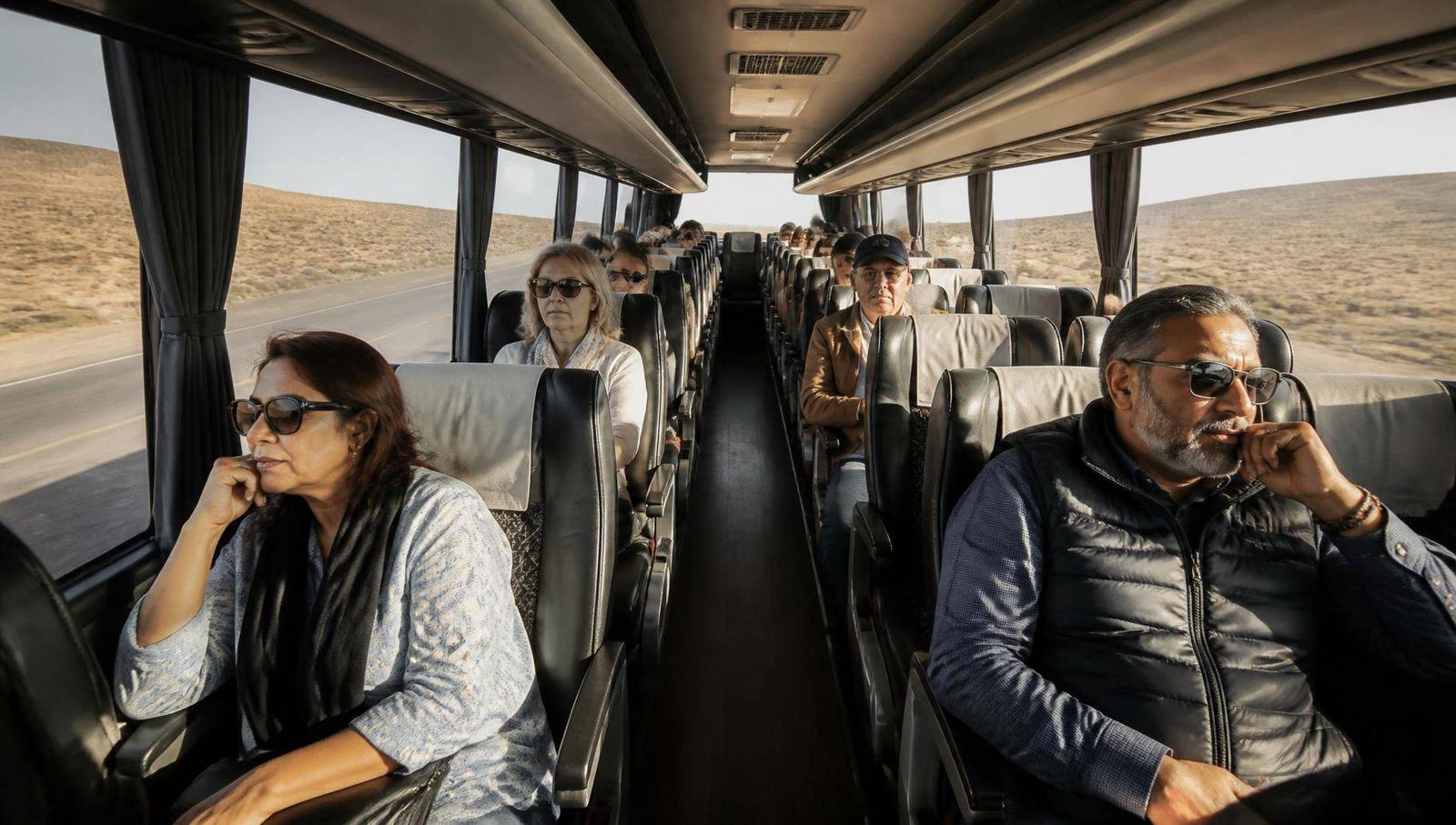 Interior of a modern touring coach with seated travellers on a Moroccan desert road